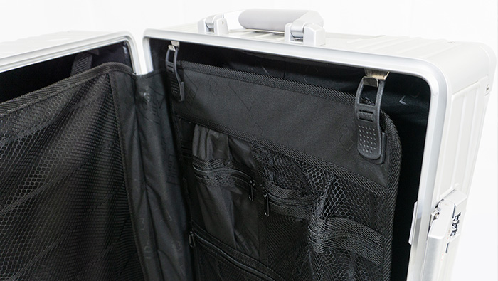 Offener silberner GUNDEL Koffer mit schwarzer, herausnehmbarer Innenaufteilung und Netztaschen.