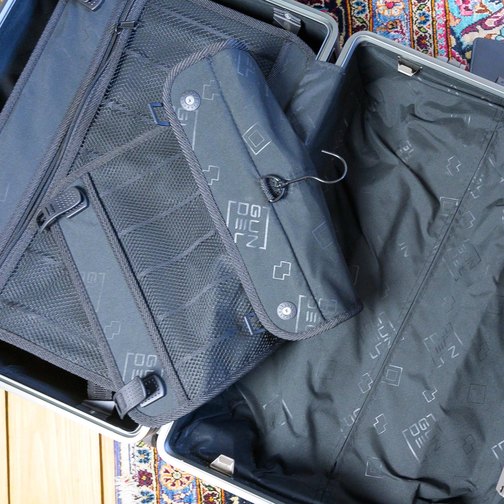 Offener GUNDEL Koffer mit herausnehmbarer Kosmetiktasche, Netzfächern und gemustertem Innenfutter.
