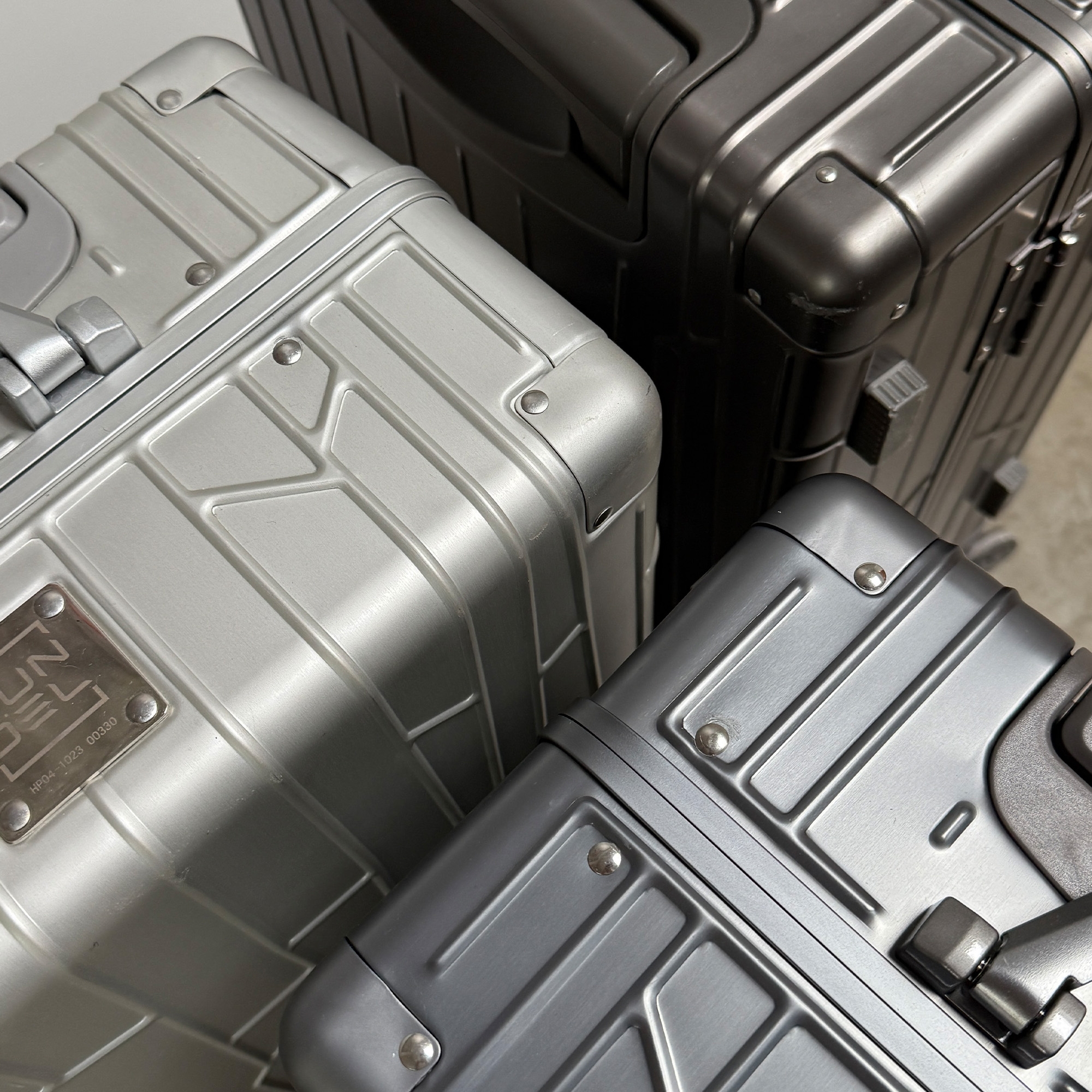 GUNDEL Space Grey suitcase with a telescopic handle stands next to a pool with a blue mosaic edge.