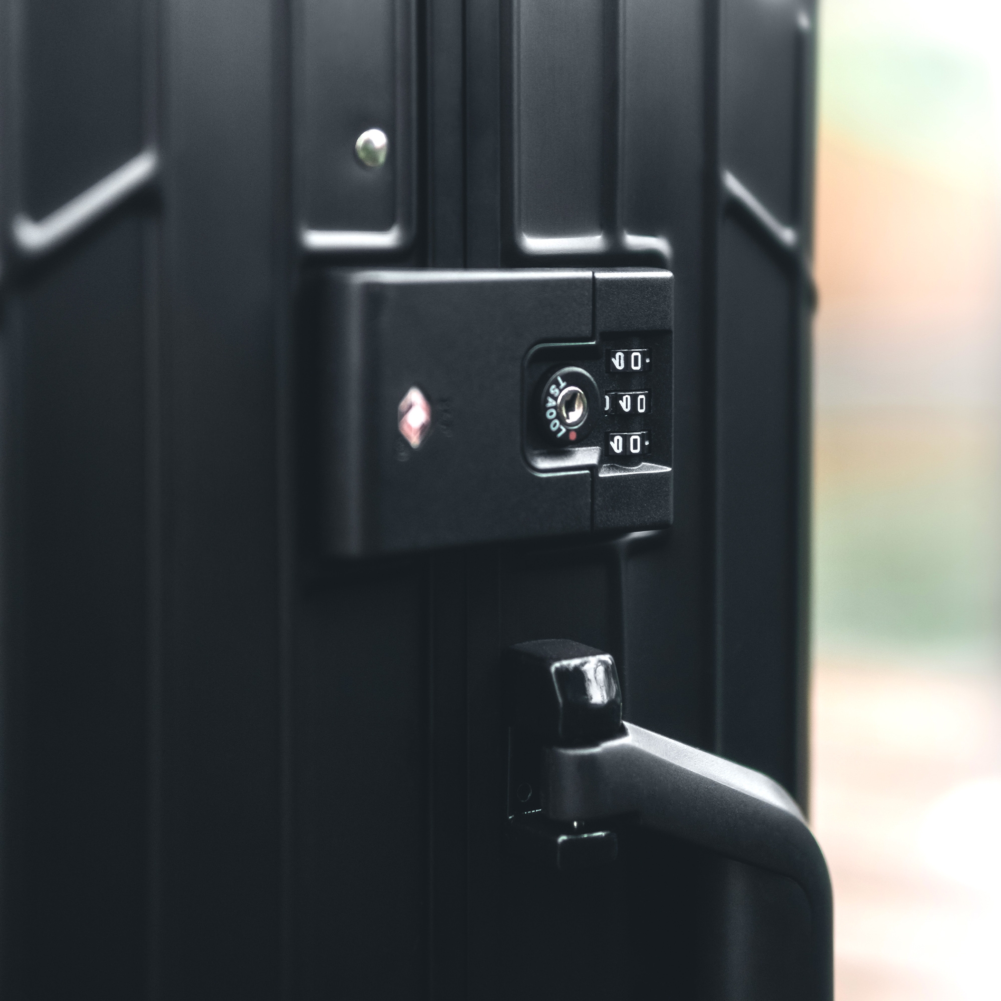 Nahaufnahme eines schwarzen GUNDEL Koffers mit integriertem TSA-Zahlenschloss und Griff.